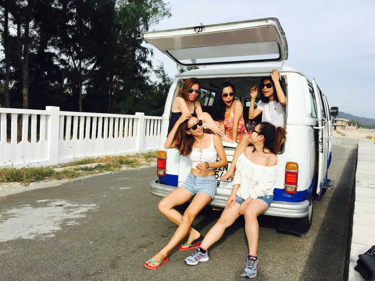 Fünf Freundinnen am Kofferraum eines Vans